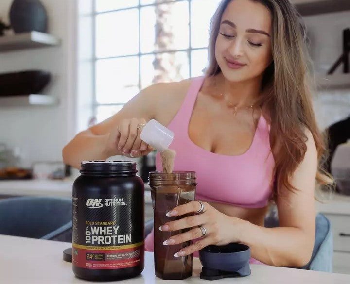Optimum Nutrition Gold Standard 100% Whey Protein, 2.73 kg container, being prepared as a protein shake