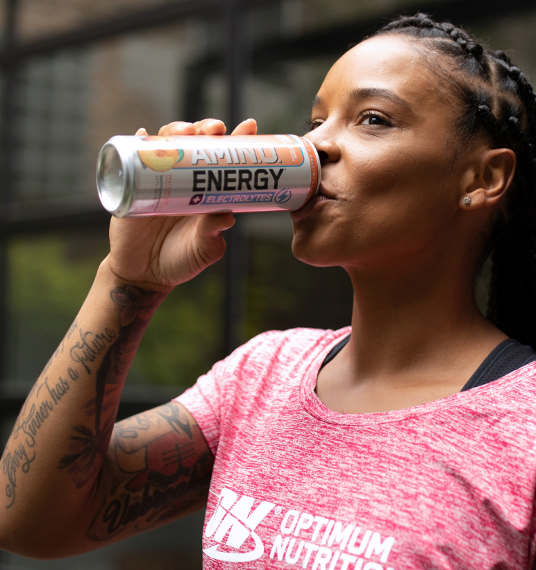 Optimum Nutrition Amino Energy drink can held by a person wearing an Optimum Nutrition shirt