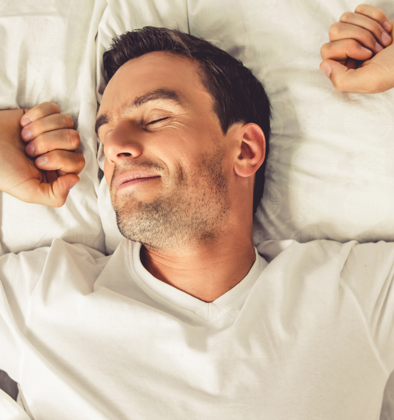 A person lying in bed, appearing relaxed and content